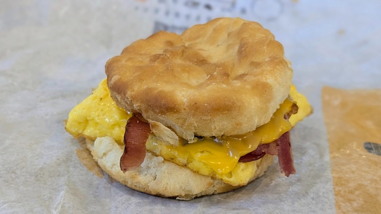 A bacon, egg, and cheese biscuit on a fast food wrapper