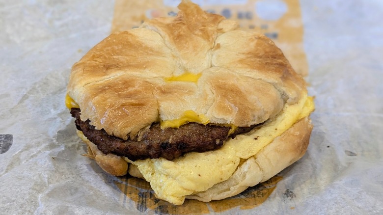 A sausage, egg, and cheese croissant on a fast food wrapper