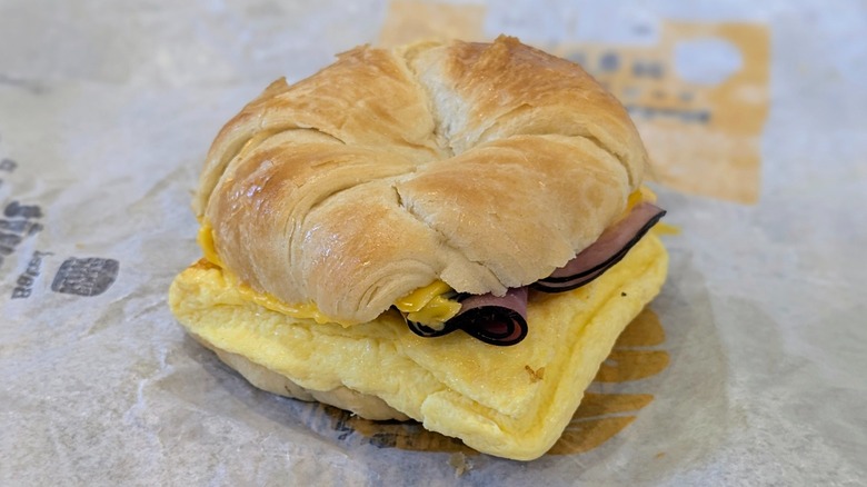 A ham, egg, and cheese croissant on a fast food wrapper