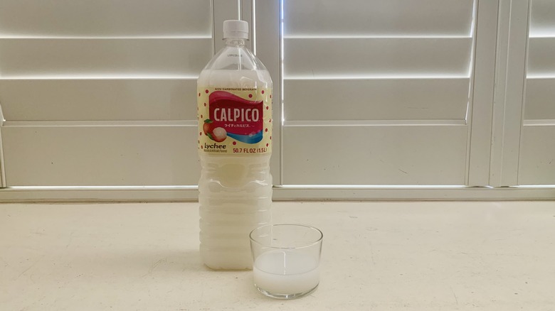 bottle of Calpico Lychee beside a half-filled glass