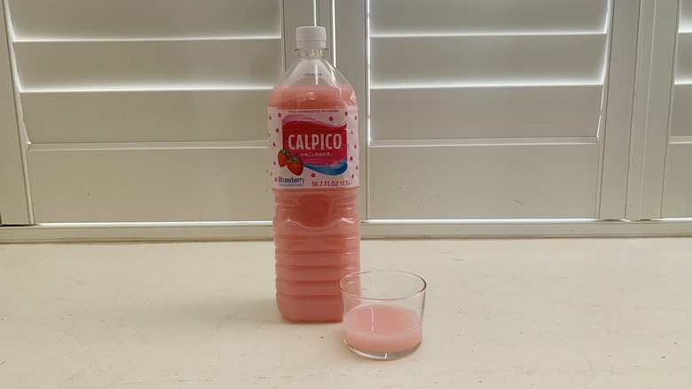 bottle of Calpico Strawberry beside a half-filled glass