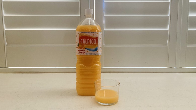 bottle of Calpico Mandarin Orange beside a half-filled glass