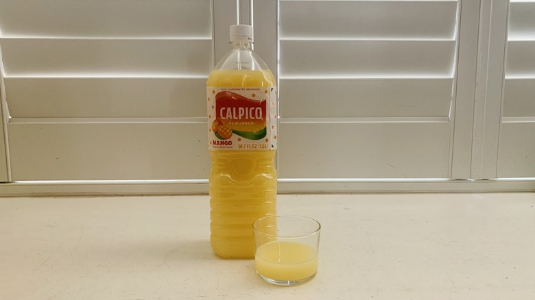 bottle of Calpico Mango beside a half-filled glass