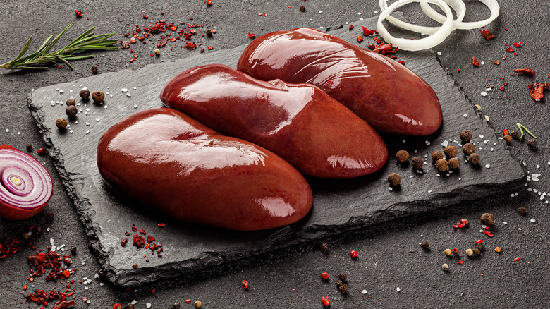 three raw livers on a slate