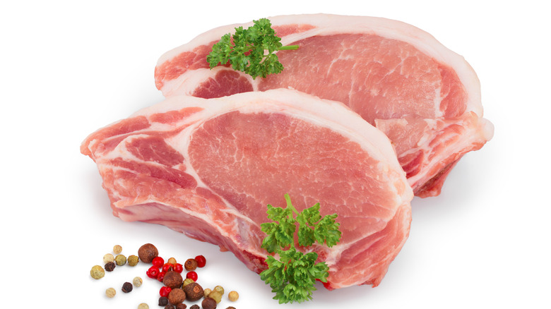 two raw pork chops with parsley