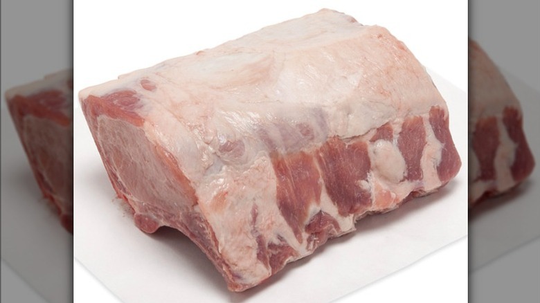 raw pork rib roast on white cutting board