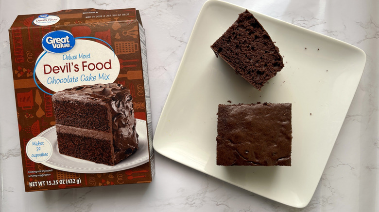Two pieces Great Value devil's food chocolate cake on plate next to box of chocolate cake mix