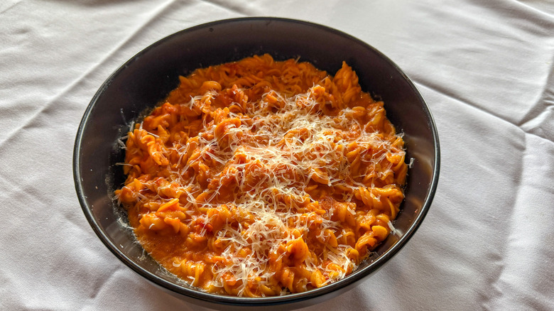 Bowl of fusilli alla vodka topped with shredded Parmesan cheese