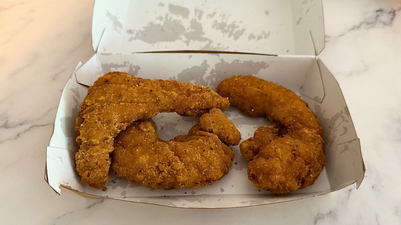Box of three McCrispy strips on marble surface