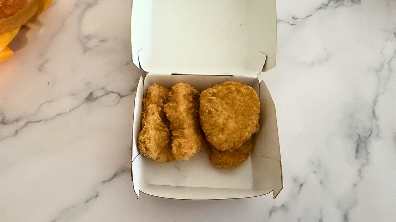 Container with four McNuggets on marble surface