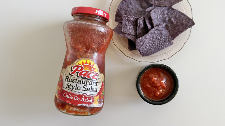 A jar of Chile De Árbol salsa on a table