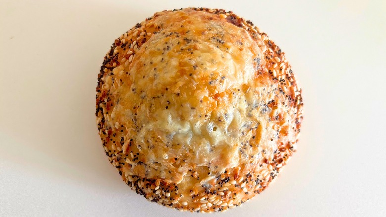 Top-down shot of Panera Asiago Everything bagel on white surface