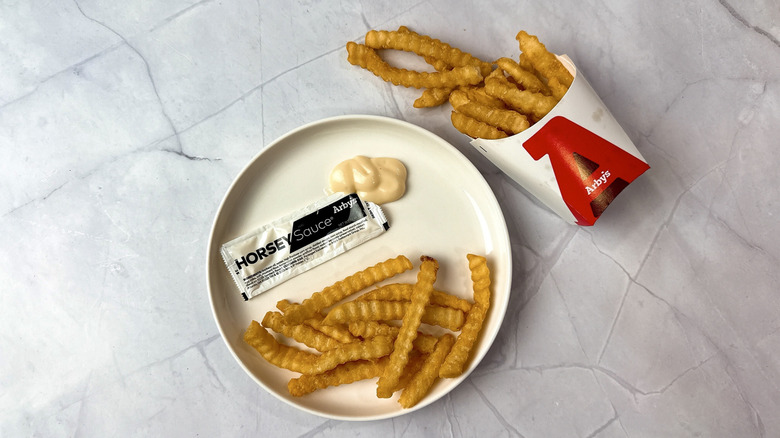Arby's horsey sauce and french fries on a plate