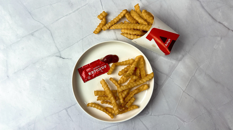 Arby's ketchup and french fries on a white plate