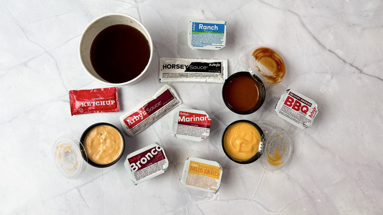 12 Arby's sauces on a white counter