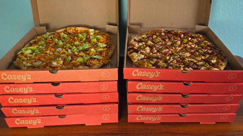 Ten boxes of Casey's large pizzas with the two top boxes open to reveal pizzas