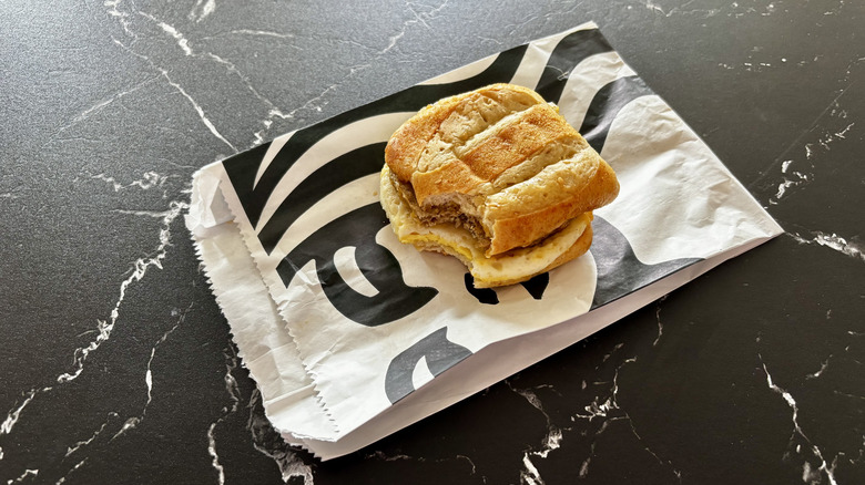 Starbucks' impossible sausage breakfast sandwich on wrapper with one bite taken