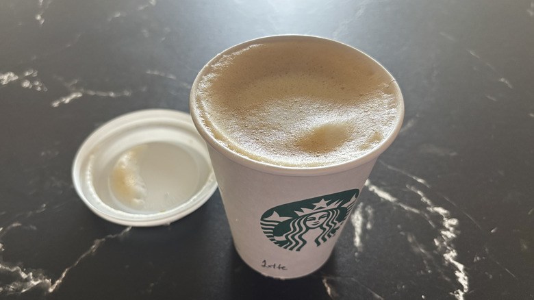 Starbucks latte with lid removed from cup