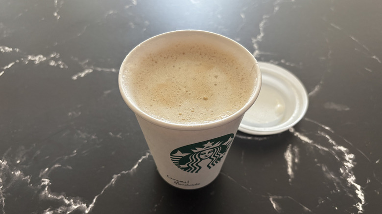 Starbucks caramel macchiato with lid removed from cup