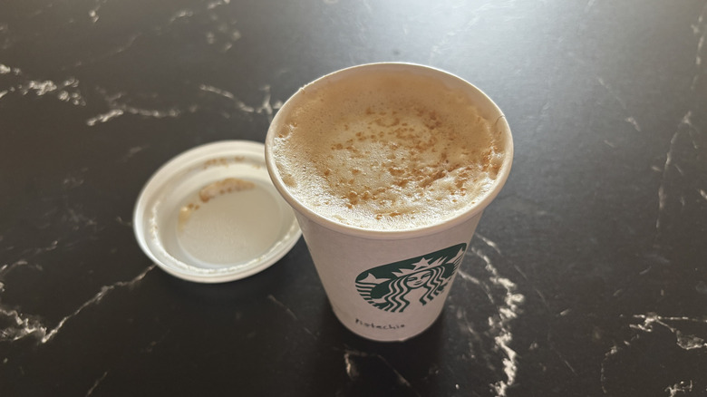 Starbucks pistachio latte with lid removed from cup