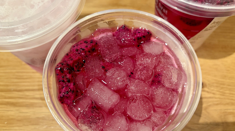A Starbucks Mango Dragonfruit Energy Refresher with other drinks