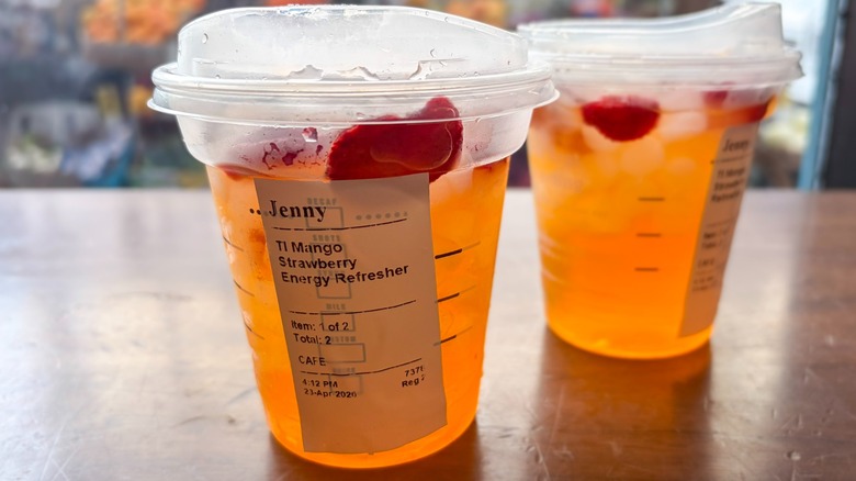 A Starbucks Mango Strawberry Energy Refresher with another drink