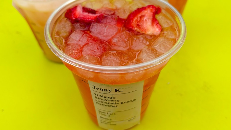 A Starbucks Mango Strawberry Lemonade Energy Refresher with other drinks