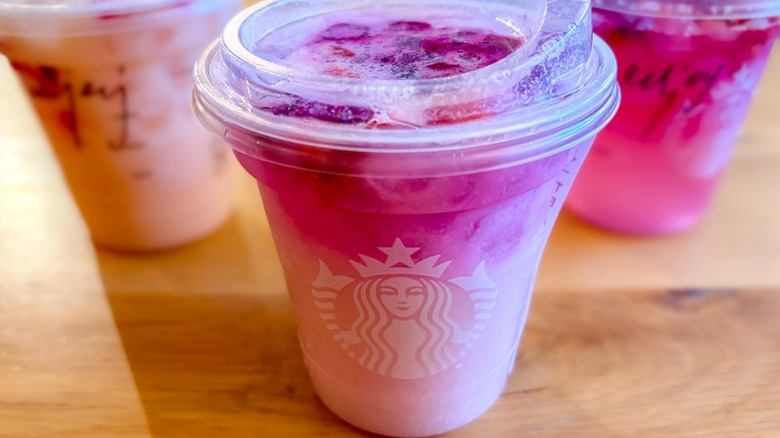 A Starbucks Pink Cannon Ball Drink with other drinks