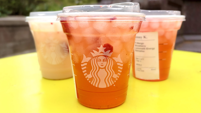 A Starbucks Strawberry Acai Energy Refresher with other drinks