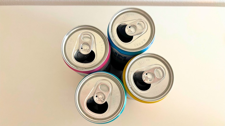 Top-down shot of four open Sun Cruiser canned cocktails on table