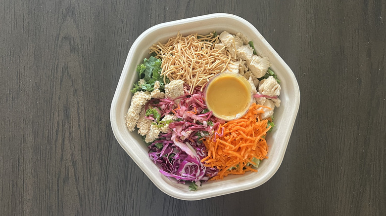 Sweetgreen Chicken Sesame Crunch salad in to-go container with crispy noodles, chicken, carrots, cabbage and a creamy dressing