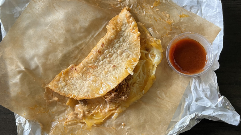 Taco Bell Shredded Beef Dipping Taco with red sauce.