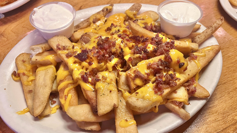 Plate loaded with cheese fries and bacon