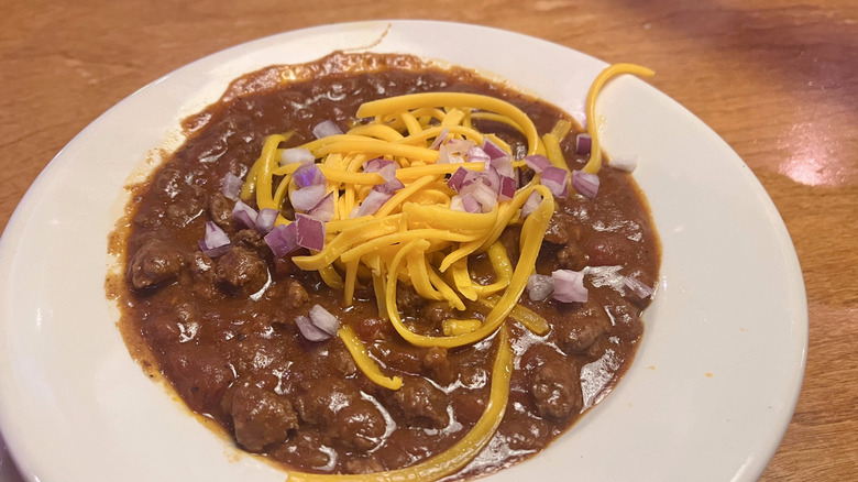 Texas red chili with cheese and onions in a bowl