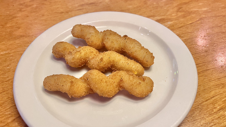 Three mozzarella twists on a white plate
