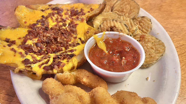 View of a combo platter with pickles, tater skins, mozzarella twists