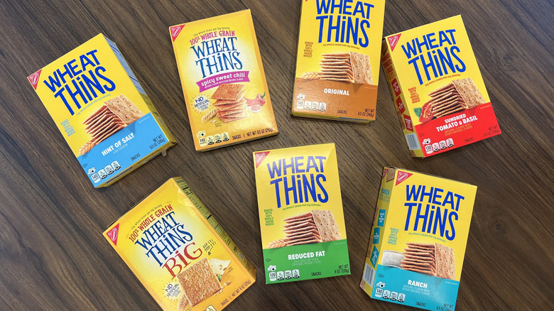 7 different boxes of Wheat Thins scattered on table.