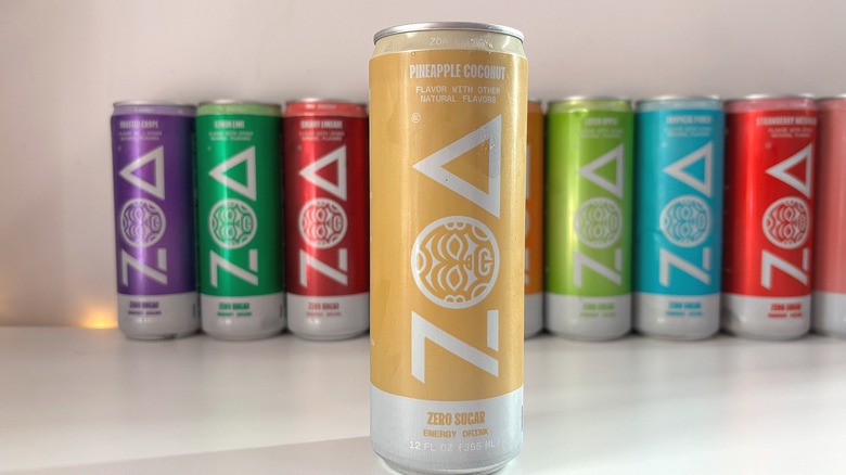 Can of Pineapple Coconut ZOA energy drink on white table, other cans behind