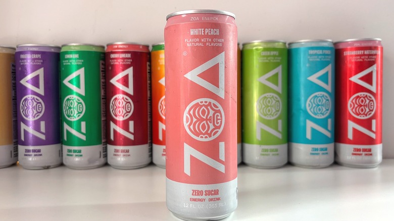 Can of White Peach ZOA energy drink on white table, other cans behind