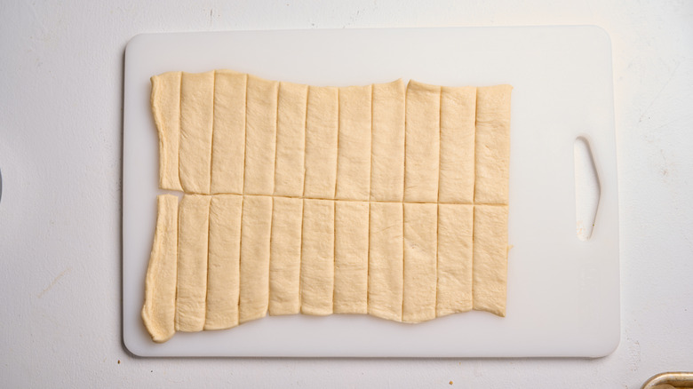 slicing croissant dough into strips