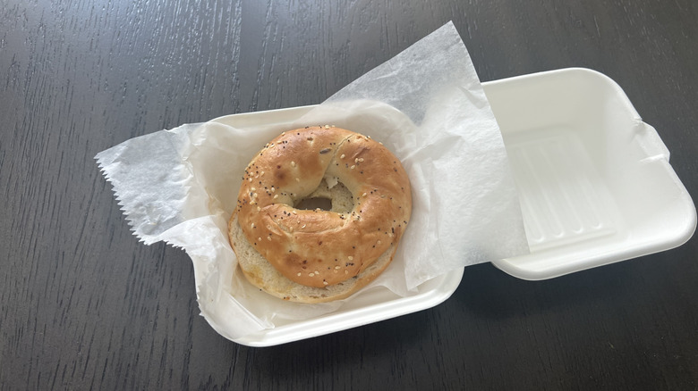Daylight Donuts everything bagel in styrofoam container.