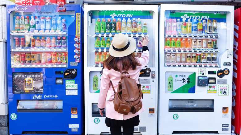 Woman and three Japanese vending machines
