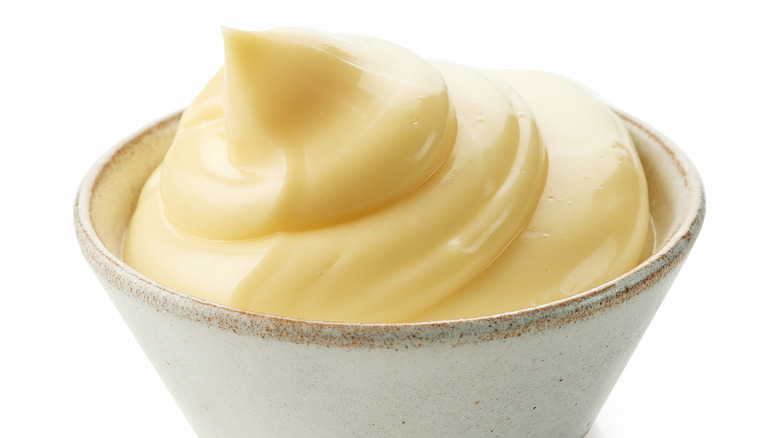 a bowl of white condiment or dip on a white background
