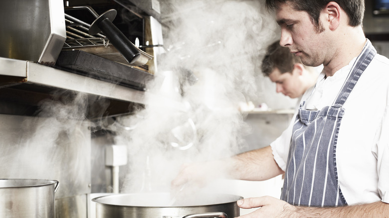 chef stirring steaming pot