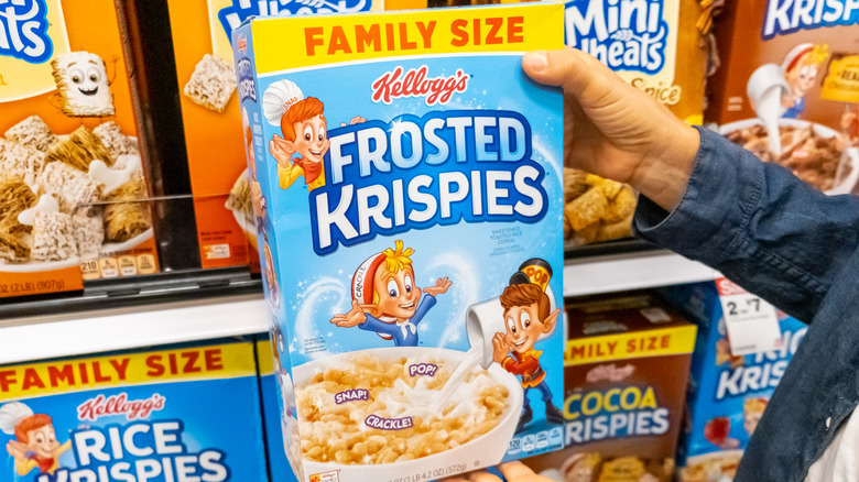 Hands holding box of Frosted Krispies in store
