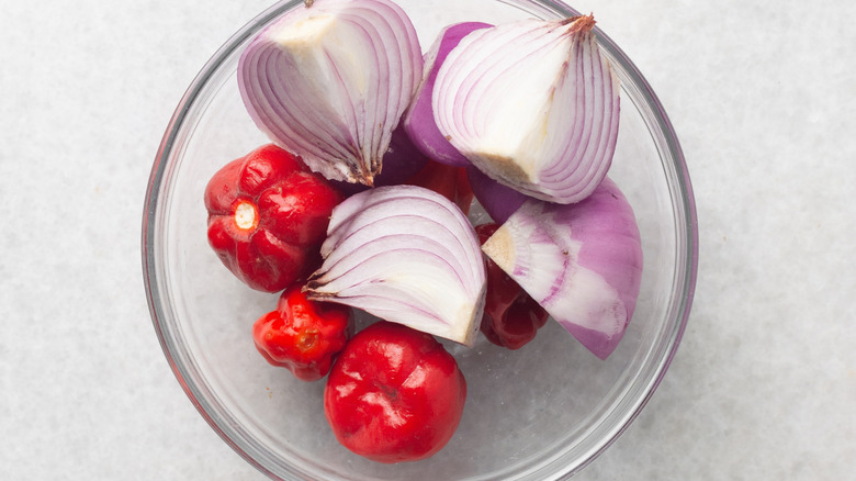 Overhead of scotch bonnet peppers and red onion