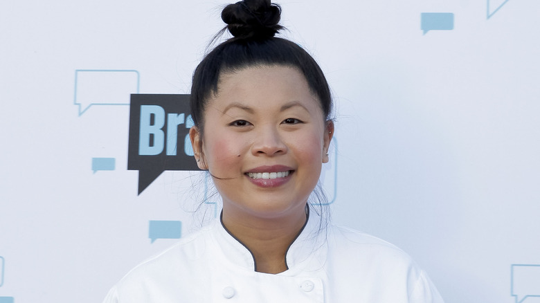 Chef Mei Lin smiles in "Top Chef" coat in front of Bravo sign