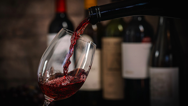 Pouring a glass of red wine.