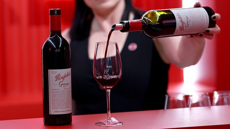 Pouring a bottle of Penfolds Grange into a glass.