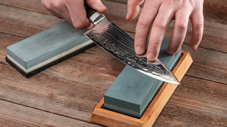 Sharpening a Damascus steel chef's knife on a whetstone